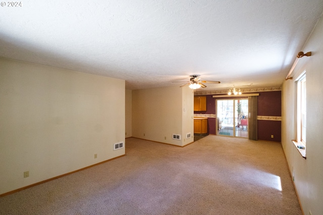 unfurnished living room with visible vents, a textured ceiling, and baseboards