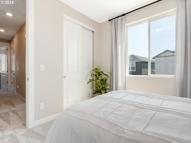 bedroom featuring light colored carpet and a closet