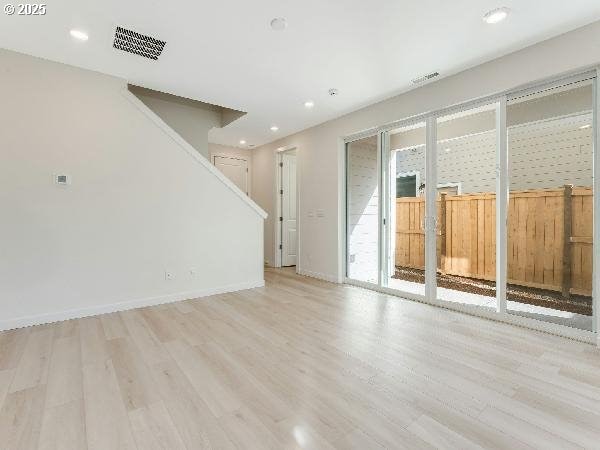 unfurnished room with light wood-type flooring, baseboards, visible vents, and recessed lighting