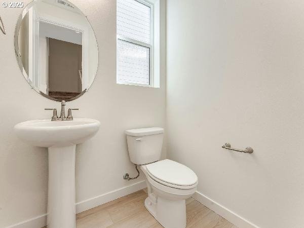 bathroom featuring a sink, toilet, and baseboards