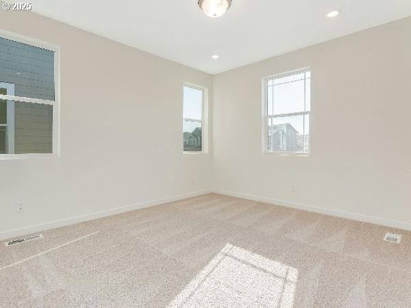 unfurnished room with carpet floors, recessed lighting, visible vents, and baseboards