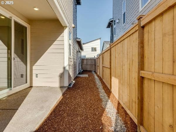 view of side of home featuring fence