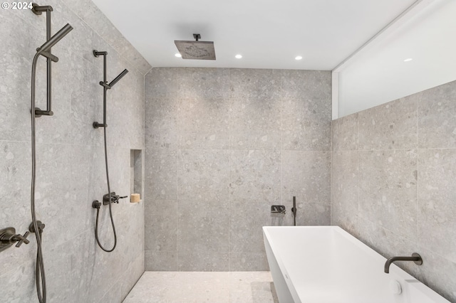 bathroom with tile walls and plus walk in shower