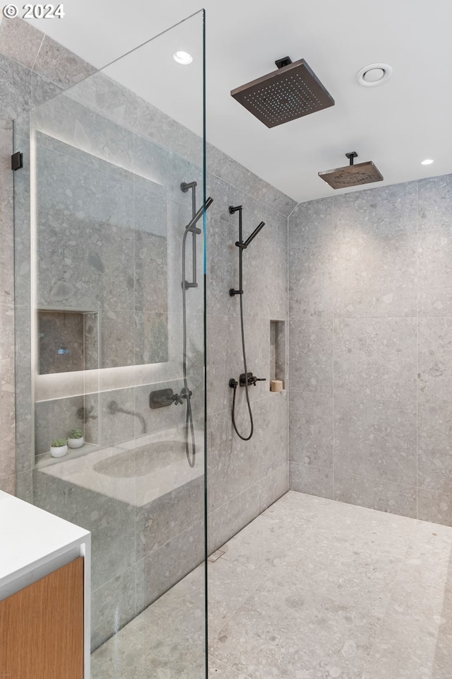 bathroom featuring a tile shower and vanity