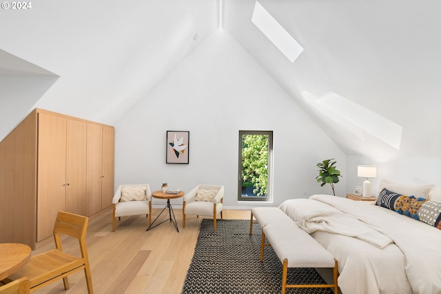 bedroom featuring lofted ceiling with skylight and light hardwood / wood-style floors