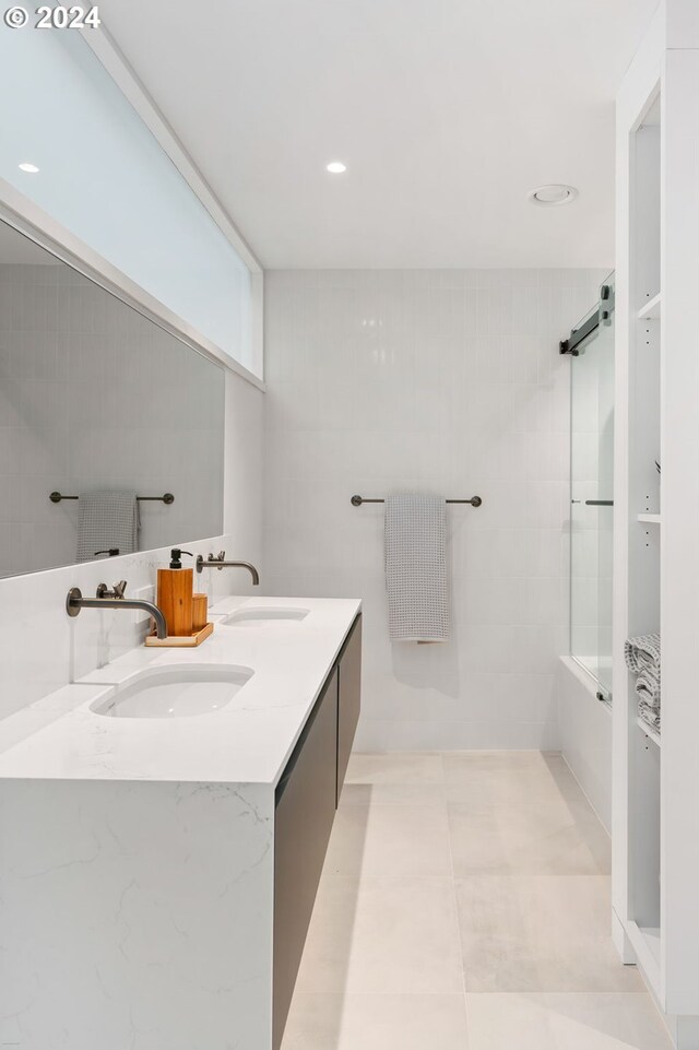 bathroom with tile patterned flooring, tiled shower / bath, and vanity