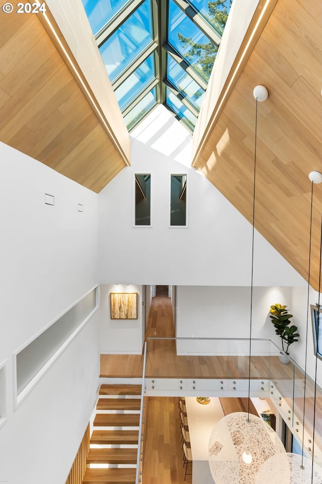 stairs with a skylight and hardwood / wood-style flooring