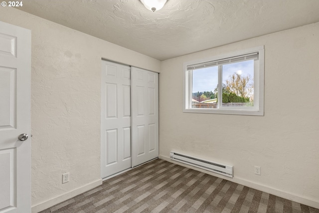 unfurnished bedroom featuring a baseboard radiator, a closet, a textured ceiling, and carpet