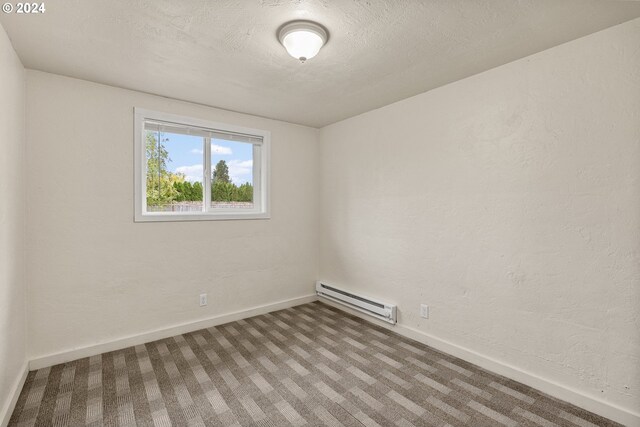 spare room featuring carpet and a baseboard heating unit