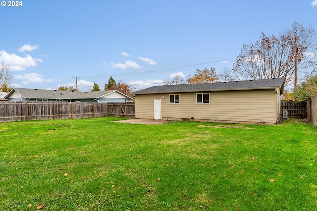 rear view of property with a lawn and a patio