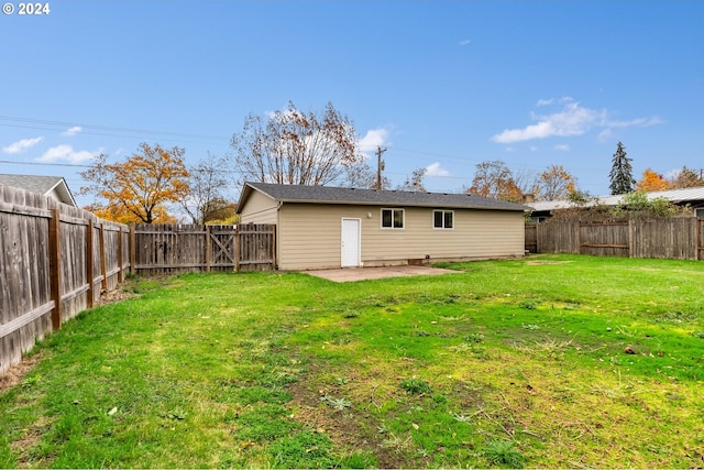 rear view of house with a lawn and a patio