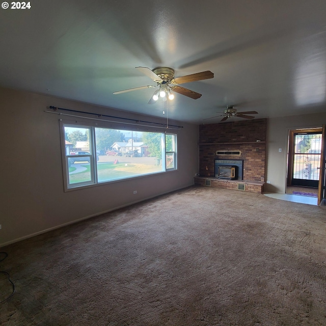 unfurnished living room featuring ceiling fan, carpet floors, and a fireplace