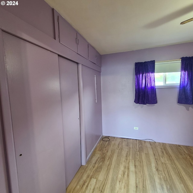 unfurnished bedroom with a closet, light hardwood / wood-style flooring, and ceiling fan