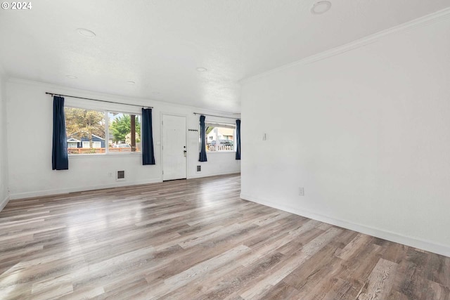 empty room with hardwood / wood-style flooring and ornamental molding