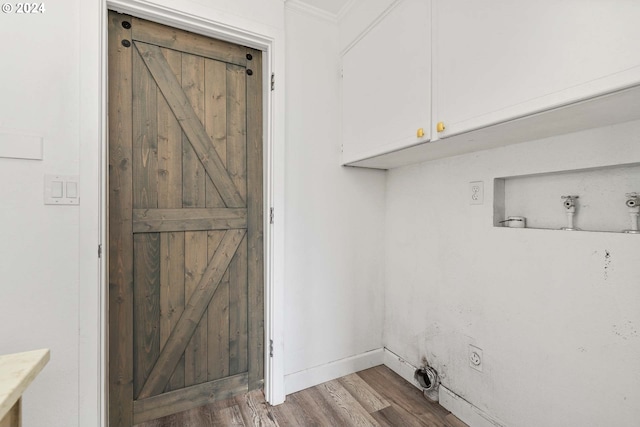 laundry area with hardwood / wood-style floors and cabinets