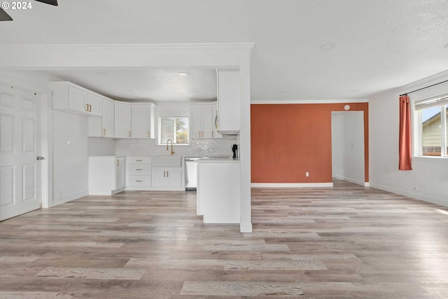 kitchen featuring white cabinets, sink, dishwasher, tasteful backsplash, and light wood-type flooring