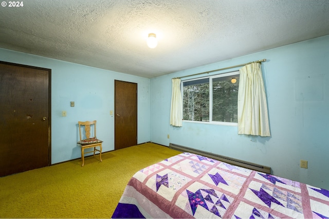 carpeted bedroom with a textured ceiling and a baseboard heating unit