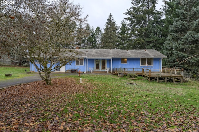 back of property with a yard and a wooden deck