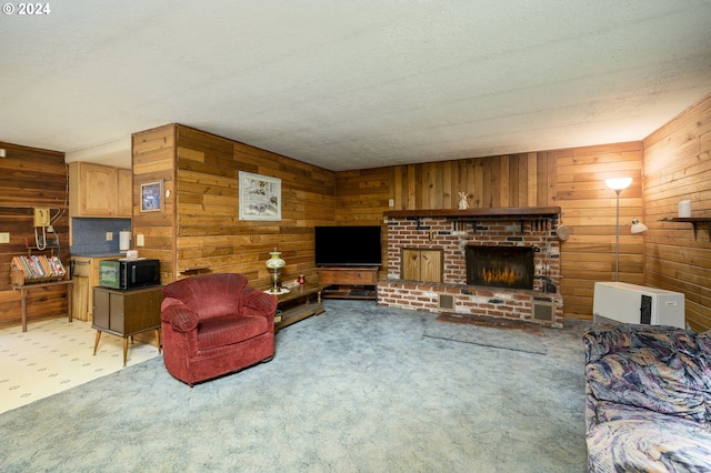 carpeted living room with a textured ceiling, wood walls, and a fireplace