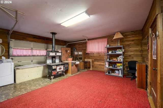 basement with carpet floors, washer / clothes dryer, and wooden walls