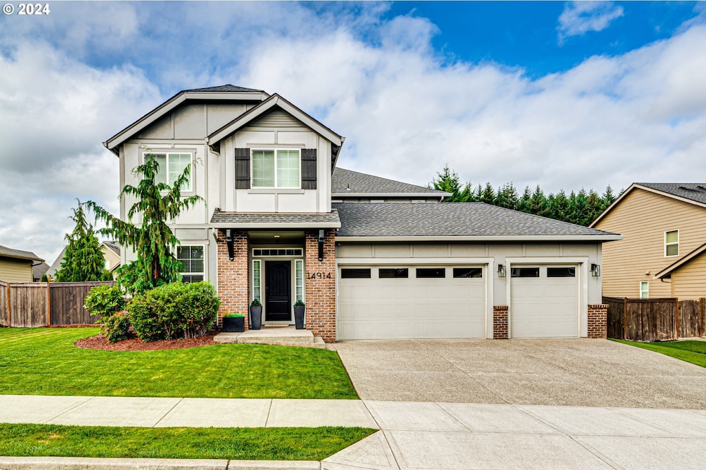 craftsman house with a front lawn and a garage