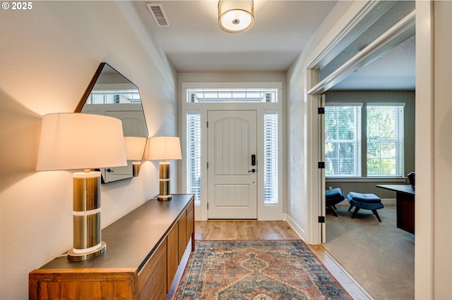 entrance foyer featuring a textured ceiling and light wood-type flooring