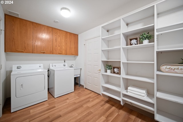 1205 NW 132nd St Unit B, Vancouver, WA 98685 - washroom featuring washing machine and dryer, cabinet space, and light wood-type flooring
