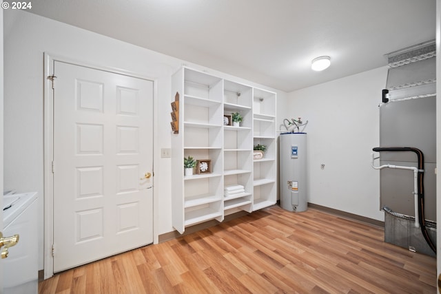 interior space featuring separate washer and dryer, light hardwood / wood-style flooring, and water heater