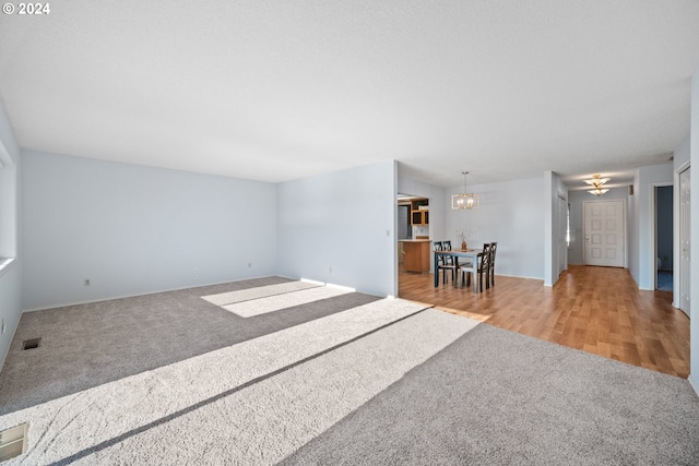 empty room featuring a chandelier and light hardwood / wood-style flooring