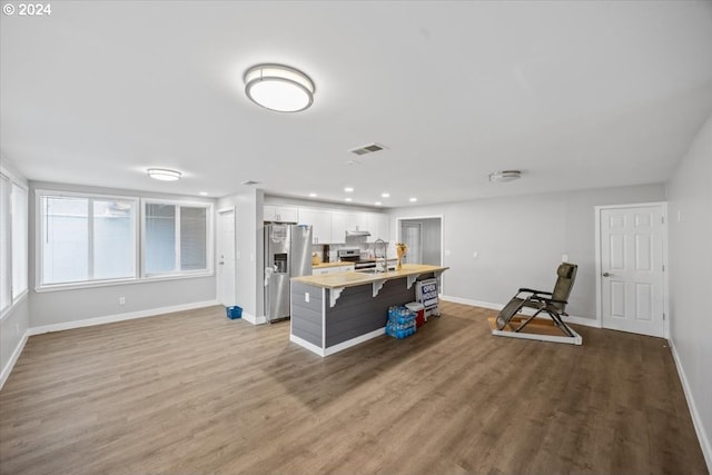 kitchen featuring white cabinetry, a center island, wood-type flooring, and appliances with stainless steel finishes