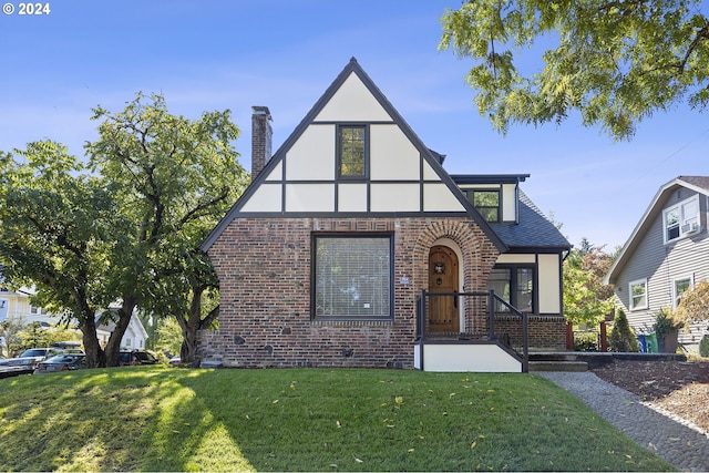 english style home with a front yard