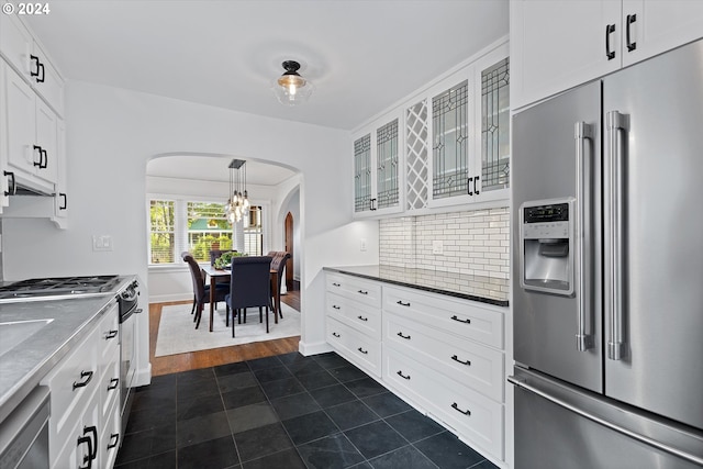 kitchen with tasteful backsplash, dark hardwood / wood-style flooring, appliances with stainless steel finishes, white cabinetry, and decorative light fixtures