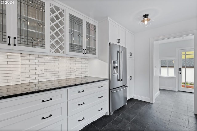 kitchen with decorative backsplash, white cabinets, high end refrigerator, and dark tile patterned flooring