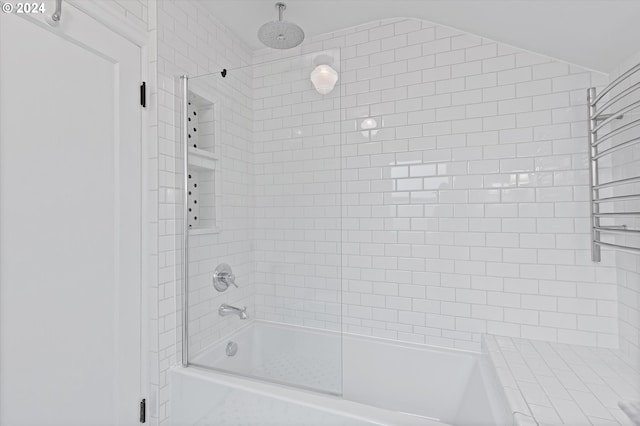 bathroom featuring combined bath / shower with glass door and lofted ceiling