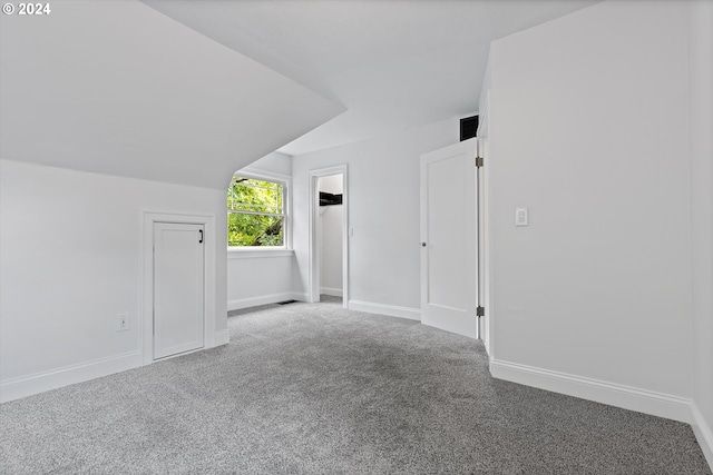 bonus room featuring lofted ceiling and carpet flooring