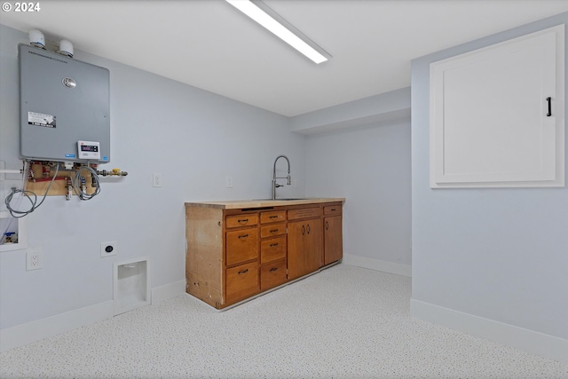 laundry area with hookup for a washing machine, sink, hookup for an electric dryer, water heater, and cabinets