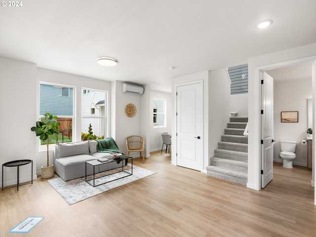 living room with light hardwood / wood-style flooring and a wall mounted AC