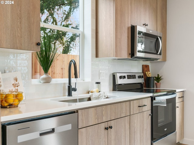 kitchen with sink, stainless steel appliances, tasteful backsplash, and light brown cabinets