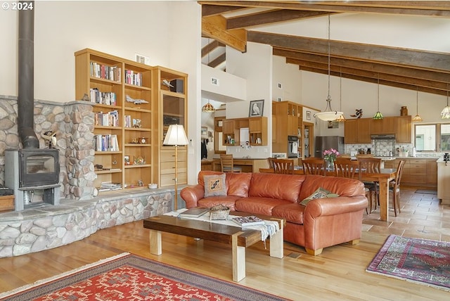 17252 N Applegate Rd, Grants Pass, OR 97527 - living room with high vaulted ceiling, beamed ceiling, a wood stove, and light wood-type flooring