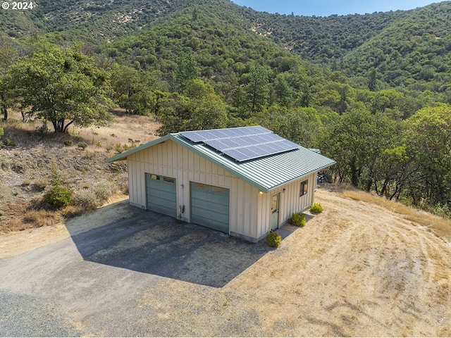 17252 N Applegate Rd, Grants Pass, OR 97527 - detached garage with solar panels, a view of trees, and driveway