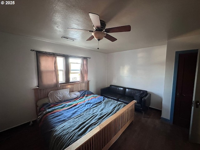 bedroom featuring dark hardwood / wood-style floors, a textured ceiling, and ceiling fan