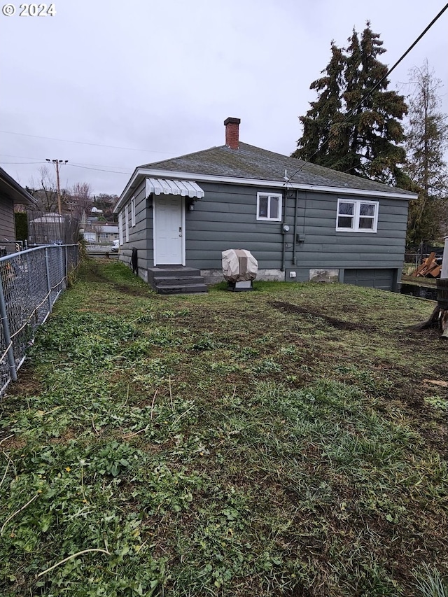 rear view of house featuring a lawn