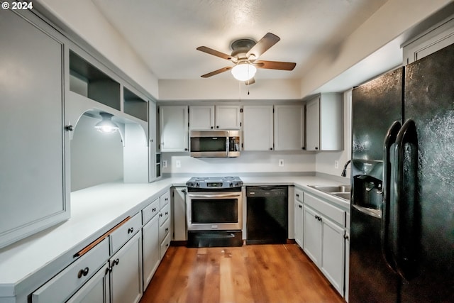 kitchen featuring gray cabinetry, black appliances, sink, light hardwood / wood-style floors, and ceiling fan