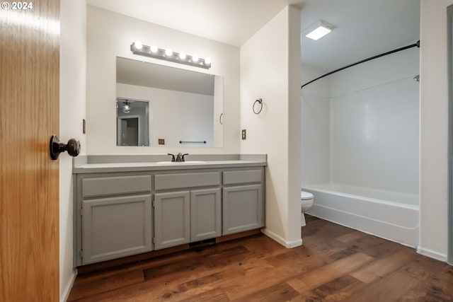 full bathroom with vanity, toilet, hardwood / wood-style flooring, and tub / shower combination