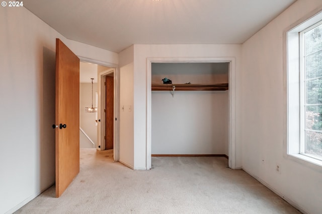 unfurnished bedroom featuring a closet and light carpet