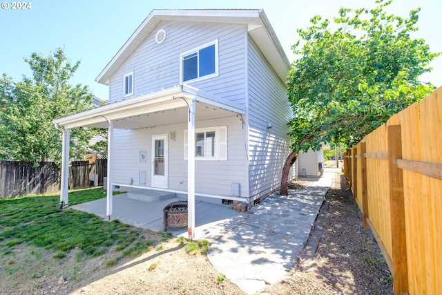 rear view of property with an outdoor fire pit and a patio