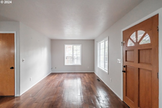 foyer featuring a textured ceiling and dark hardwood / wood-style floors