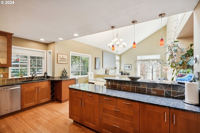 kitchen with dishwasher, sink, lofted ceiling, light wood-type flooring, and dark stone counters