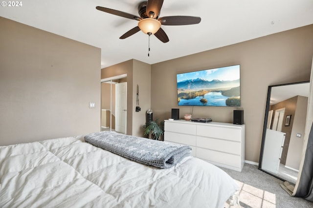 bedroom with a closet, ceiling fan, and light carpet