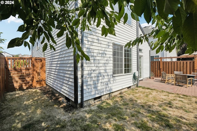 view of home's exterior with a patio area and a lawn